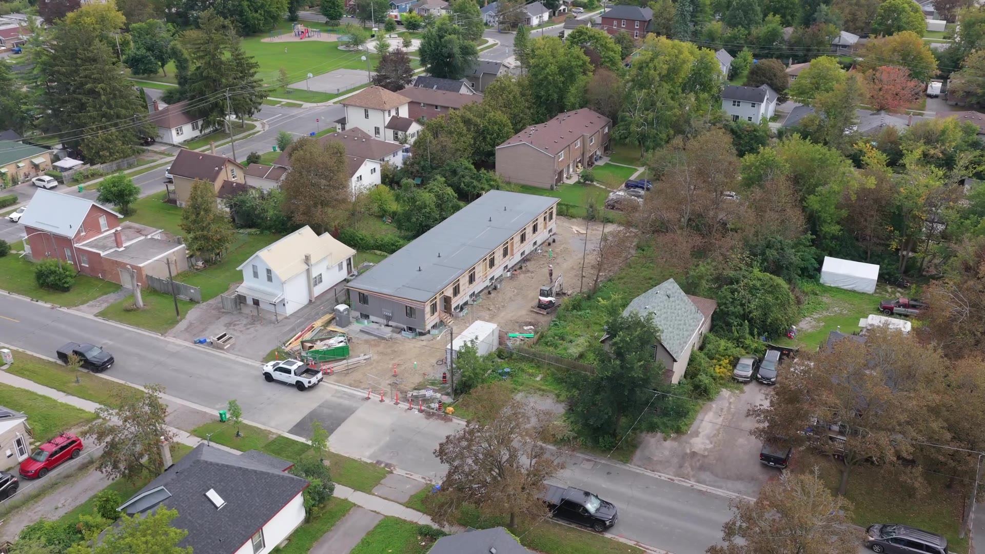 Aerial view of four rental townhomes under construction at Frank Street, Peterborough, with the roof on