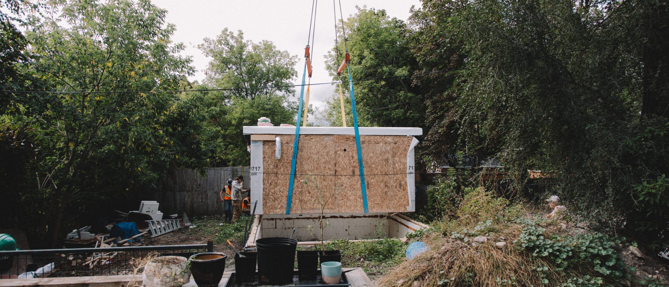A factory-built module lifted over the existing house into the rear yard in Peterborough